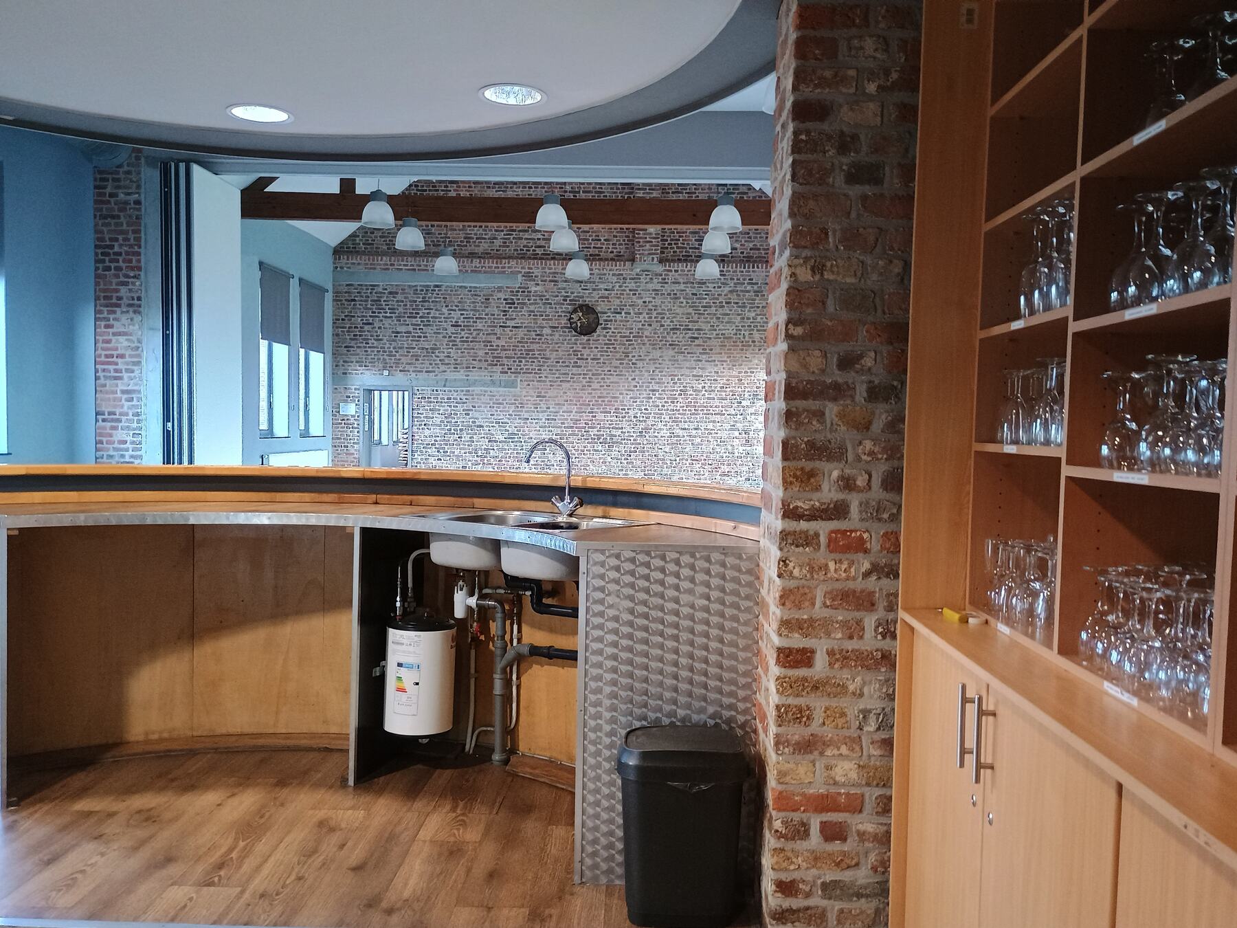 Achter de bar met spoelbak en glazenkast