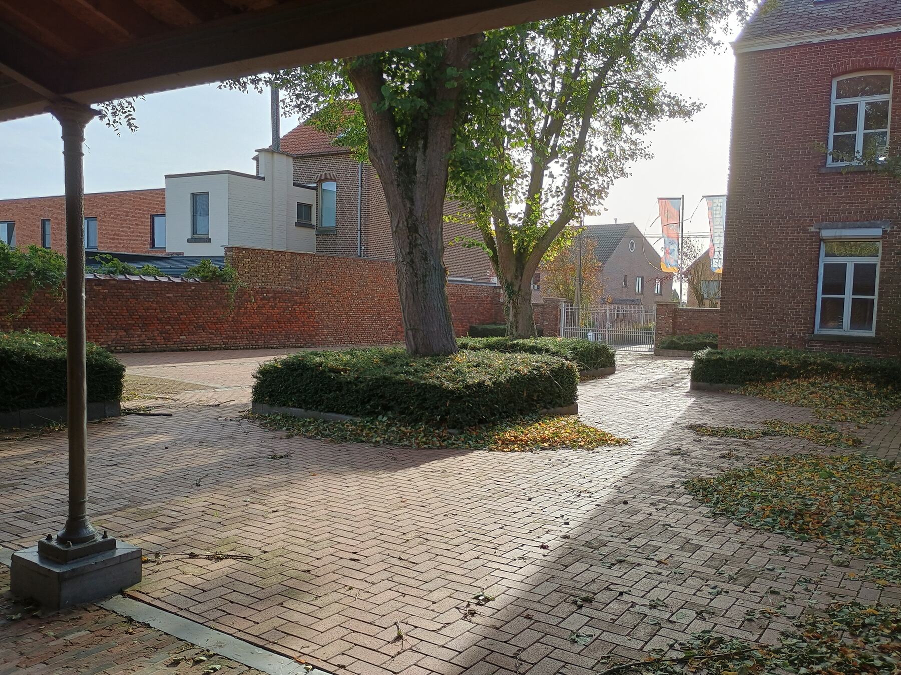 Voorplein met bomen onder het afdak